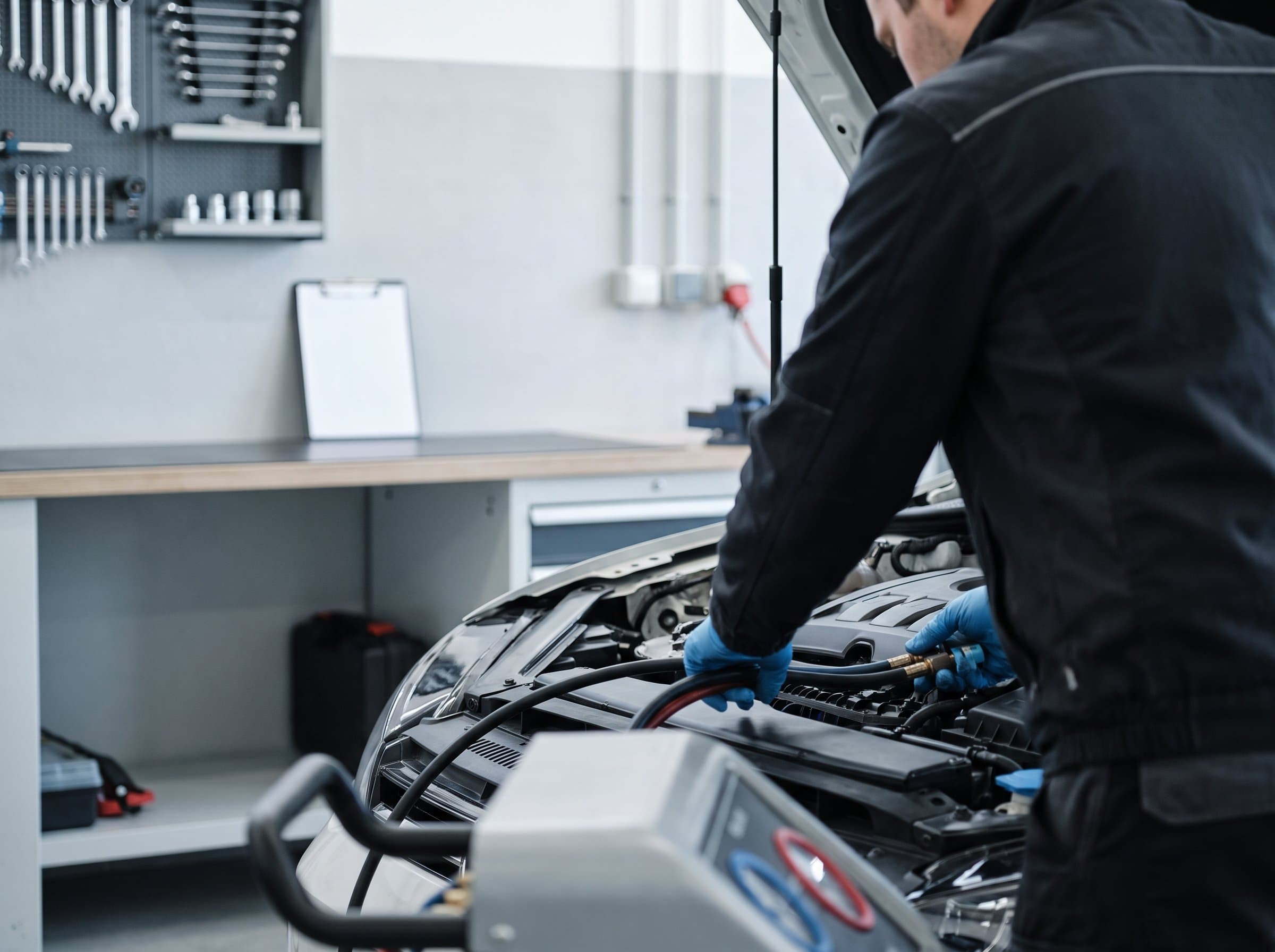 Im offenen Motorraum werden die Schläuche des Klimaservicegeräts angeschlossen